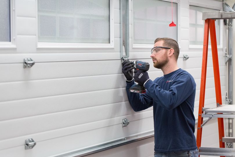 Garage door technician working on a door.